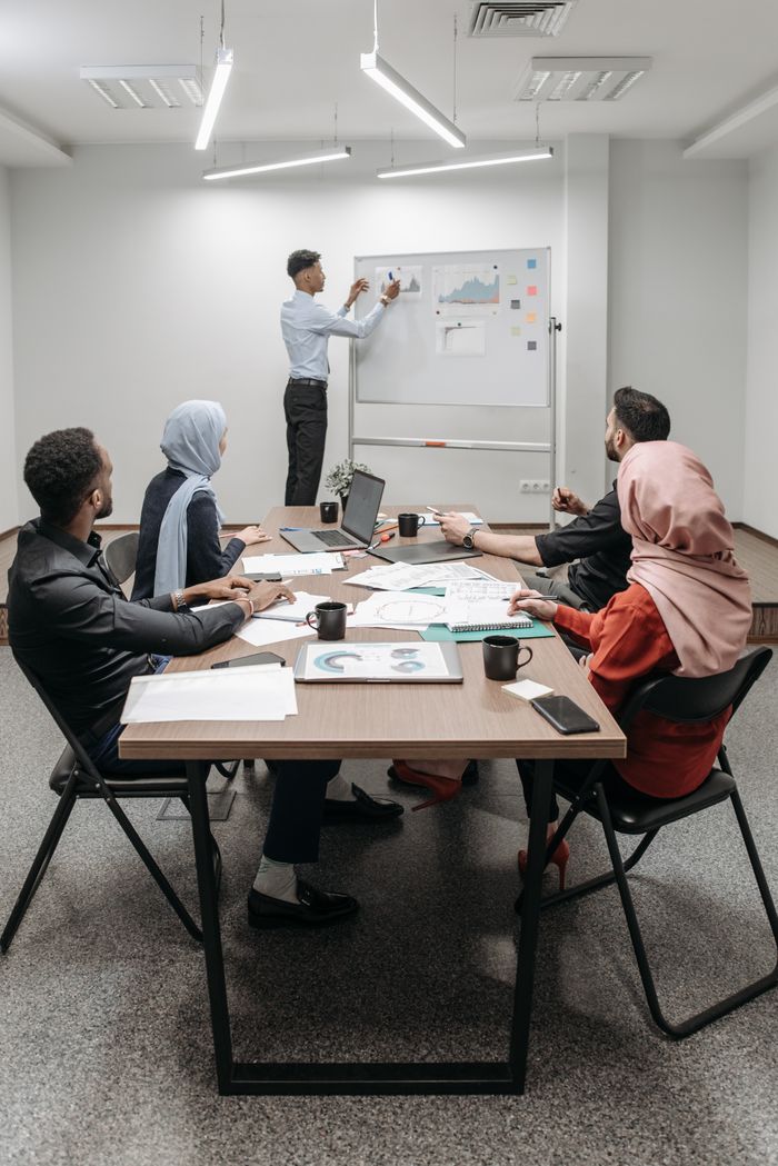 about-01 Business meeting with diverse team discussing ideas in modern office.